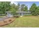 Landscaped single-story home featuring an attached garage and a lush front yard with mature trees at 803 Burnett Dr, Charleston, SC 29412