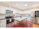 Bright kitchen features white cabinets, stainless steel appliances, kitchen island, and hardwood floors at 803 Burnett Dr, Charleston, SC 29412