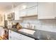 Close up of kitchen with white cabinets, stainless appliances, subway tile backsplash and dark countertops at 803 Burnett Dr, Charleston, SC 29412