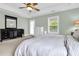 Well-lit main bedroom with large bed, dresser, mirror, windows and door to the exterior at 911 Hunt Club, Charleston, SC 29414