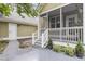 Screened-in porch with white railings, adjacent to a patio, exterior door, and landscaping at 911 Hunt Club, Charleston, SC 29414