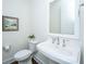 Charming half-bathroom boasts a sleek pedestal sink, a decorative mirror, and elegant fixtures at 977 Warrick Oaks Ln, Mount Pleasant, SC 29464