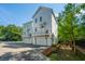 Charming exterior view of new construction townhomes featuring white siding and private balconies above garages at 977 Warrick Oaks Ln, Mount Pleasant, SC 29464