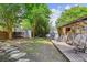 Backyard features mature trees, stone path, shed, and an outdoor kitchen area with an egg chair for outdoor relaxation at 1007 Whitlow Blvd, Summerville, SC 29483