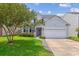 Charming two-story home with a manicured lawn, tree, driveway, and attached two-car garage at 1007 Whitlow Blvd, Summerville, SC 29483