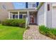Inviting front porch with brick pathway, white picket fence, and beautiful landscaping and shrubs at 1007 Whitlow Blvd, Summerville, SC 29483