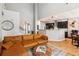 Bright open-concept living room features a large brown leather sofa and view to the kitchen at 1007 Whitlow Blvd, Summerville, SC 29483