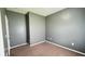 Small bedroom with gray walls, carpet, white baseboards, and a door to the hallway at 115 Hyrne Dr, Goose Creek, SC 29445