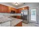 Modern kitchen boasts stainless steel appliances, granite counters, wood cabinets, and backyard access at 116 Venezia Ct, Ladson, SC 29456