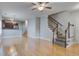 Bright living space with light wood floors and a staircase, offering a view into the adjacent kitchen area at 116 Venezia Ct, Ladson, SC 29456