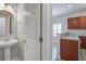 Charming powder room featuring a pedestal sink, round mirror, and doorway to the kitchen at 116 Venezia Ct, Ladson, SC 29456