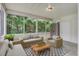 Inviting screened porch featuring comfortable seating, a wooden coffee table, and views of the lush backyard at 116 Venezia Ct, Ladson, SC 29456