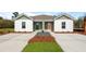 Charming exterior view of a duplex featuring a well-manicured lawn and double driveway at 117 Mims Academy Dr, Harleyville, SC 29448