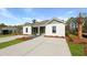 Charming exterior view of a duplex featuring a well-manicured lawn and a long driveway at 117 Mims Academy Dr, Harleyville, SC 29448