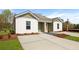 Exterior view of a duplex featuring a well-manicured lawn and a long driveway at 117 Mims Academy Dr, Harleyville, SC 29448