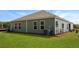 A well-maintained backyard featuring lush green grass, a modern home design, and tidy landscaping at 117 Mims Academy Dr, Harleyville, SC 29448