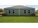 A backyard featuring green siding, windows, well-maintained landscaping, and healthy lawn at 117 Mims Academy Dr, Harleyville, SC 29448