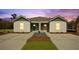 Charming duplex featuring a well-manicured lawn and a concrete driveway leading to each unit at 119 Mims Academy Dr, Harleyville, SC 29448