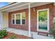 Close-up of a townhouse porch with brick detailing, a glass front door, and a welcome mat at 1201 Pine Bluff Dr, Summerville, SC 29483