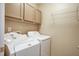 Laundry room with washer, dryer, and overhead cabinets, providing convenience and storage space at 1201 Pine Bluff Dr, Summerville, SC 29483
