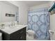 A tidy bathroom features a sleek vanity with solid surface countertops and a charming blue patterned shower curtain at 127 Longford Dr, Summerville, SC 29483