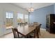 Cozy dining area featuring a rustic wooden table set and a modern chandelier above at 127 Longford Dr, Summerville, SC 29483