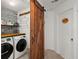 Convenient laundry room featuring a sliding barn door, washer, dryer, butcher block top, and storage shelves at 127 Longford Dr, Summerville, SC 29483