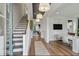 Inviting foyer with hardwood floors, stylish lighting, and easy access to the staircase and living areas at 128 Falaise St, Charleston, SC 29492
