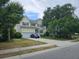 Charming two-story home with a well-manicured lawn, attached garage, and a blue car parked in the driveway at 1495 Keshi Pearl Dr, Mount Pleasant, SC 29466