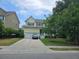 Charming two-story home with a well-manicured lawn, attached garage, and a blue car parked in the driveway at 1495 Keshi Pearl Dr, Mount Pleasant, SC 29466