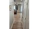 Hallway with hardwood floors leading to a kitchen, featuring light grey cabinets and an island with seating at 1495 Keshi Pearl Dr, Mount Pleasant, SC 29466
