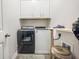 Efficient laundry room featuring a washer, dryer, and overhead storage cabinets at 1495 Keshi Pearl Dr, Mount Pleasant, SC 29466