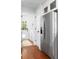 Hallway with hardwood floors that lead to a stainless steel refrigerator and laundry area at 1514 Village Sq, Mount Pleasant, SC 29464