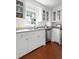 Charming kitchen features white cabinetry, granite countertops, stainless appliances, and hardwood floors at 1514 Village Sq, Mount Pleasant, SC 29464