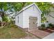 Exterior of white outbuilding with brick foundation, wood door, and well-maintained landscaping at 1514 Village Sq, Mount Pleasant, SC 29464