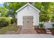 Outbuilding featuring brick foundation and wood door, set in a grassy area with white picket fence at 1514 Village Sq, Mount Pleasant, SC 29464