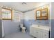 Bathroom with light blue tile, vanity, toilet, window, mirror, and medicine cabinet at 1520 Acacia St, Charleston, SC 29407