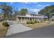 Street view showcasing this multi-level home with a sprawling driveway and manicured landscaping at 1520 Acacia St, Charleston, SC 29407