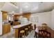 Eat-in kitchen with wood cabinetry, breakfast bar, laminate countertops, tile flooring, and stainless steel appliances at 1520 Acacia St, Charleston, SC 29407
