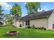 Charming backyard featuring a well-maintained lawn, mature trees, and a stone fire pit for outdoor relaxation at 1583 Southwick Dr, Johns Island, SC 29455