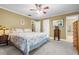 Neutral bedroom featuring white trim, ceiling fan, and doorways to ensuite and closet at 1583 Southwick Dr, Johns Island, SC 29455