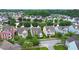 Aerial view of a neighborhood with colorful homes, mature trees, and a serene pond at 1870 Gammon St, Charleston, SC 29414