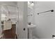 Stylish half bathroom features a pedestal sink, round mirror, and bronze fixtures next to the kitchen at 1870 Gammon St, Charleston, SC 29414