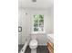 Bathroom featuring a shower, a toilet, sink, and a window with a green trees view at 19 Smith St # D, Charleston, SC 29401