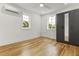 Cozy bedroom featuring hardwood floors, fresh white walls, a closet with mirrored doors, and natural light at 19 Smith St # D, Charleston, SC 29401