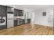 Modern kitchen featuring stainless steel appliances, sleek gray cabinets, a washer/dryer combo, and hardwood floors at 19 Smith St # D, Charleston, SC 29401
