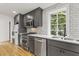 Modern kitchen featuring stainless steel appliances, sleek gray cabinets, a washer/dryer combo, and hardwood floors at 19 Smith St # D, Charleston, SC 29401