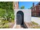 Exterior shot of a charming black door with brick steps and lush green foliage at 2 Francis St # I, Charleston, SC 29403