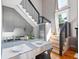 An eat-in kitchen features light grey cabinets, stainless appliances, bar seating, and stairs to another level at 2 Francis St # I, Charleston, SC 29403