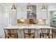 Bright kitchen features white cabinets, quartz countertops, stainless hood, brass fixtures, and seating at the island at 2048 Ten Point Dr, Charleston, SC 29492